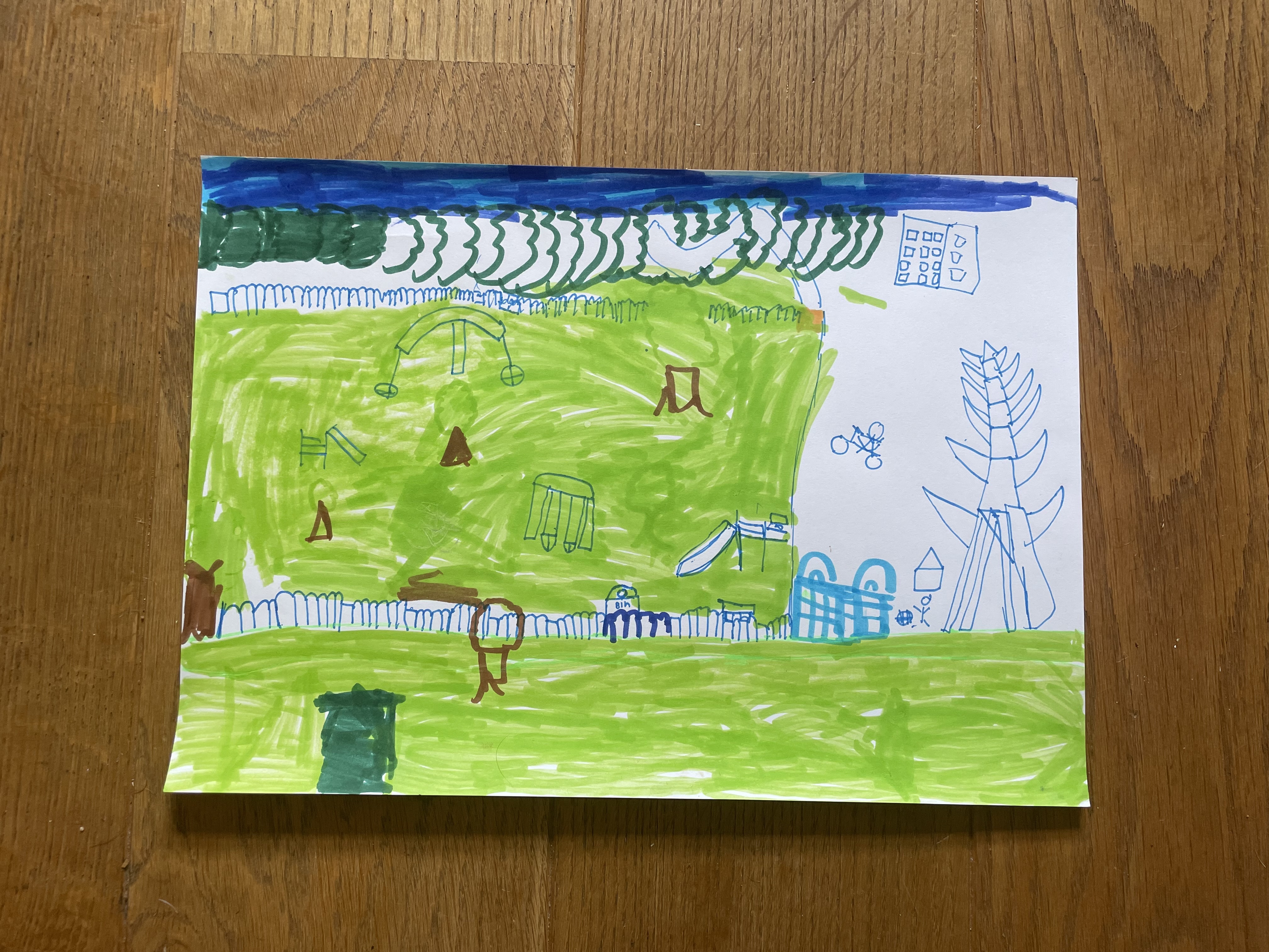 Green felt tip outlines the playground and a grassy area to the right. On the left blue outlines the stylised spiky pylon and buildings.
