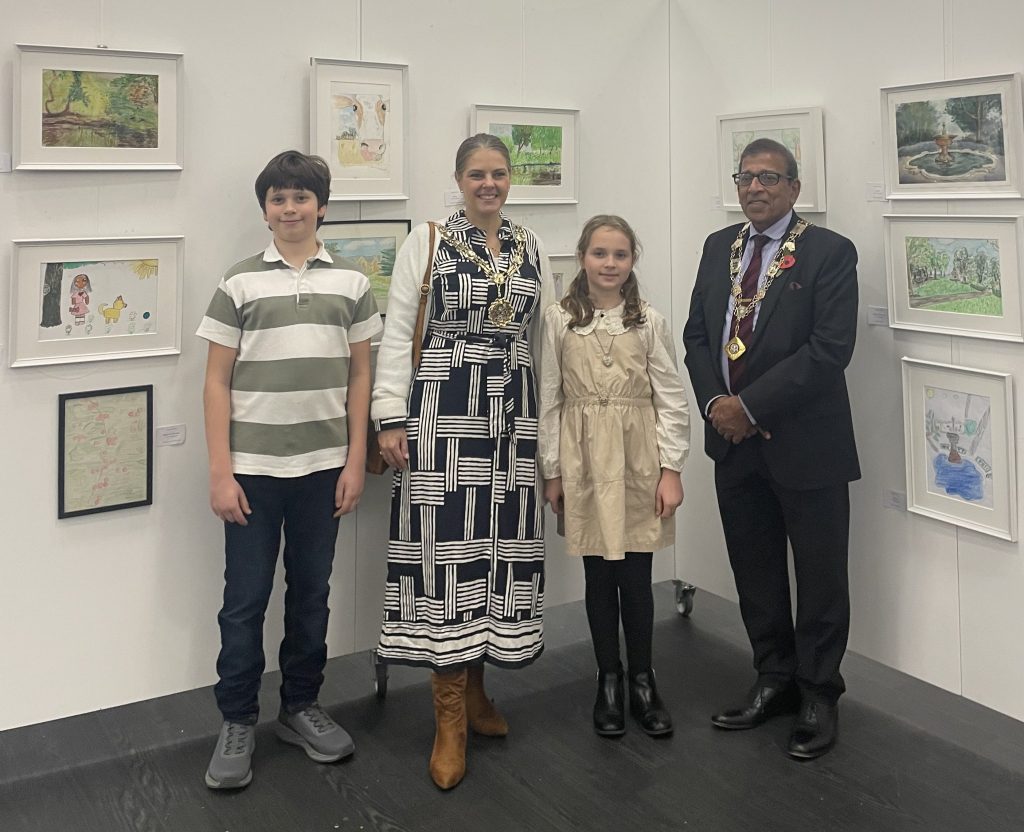 Mikolay, the Mayor of Sutton, Monica and the Deputy Mayor stand in front of a gallery hang of artworks of our park
